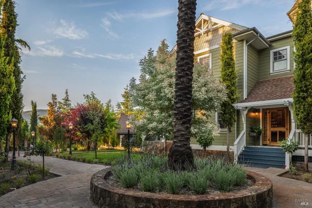 an aerial view of residential houses with outdoor space and trees