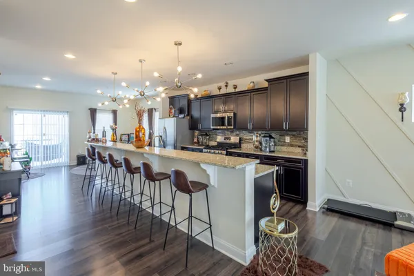 a kitchen with a dining table chairs stove refrigerator and microwave