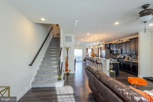 a kitchen with stainless steel appliances kitchen island granite countertop a refrigerator a stove and a sink with wooden floor