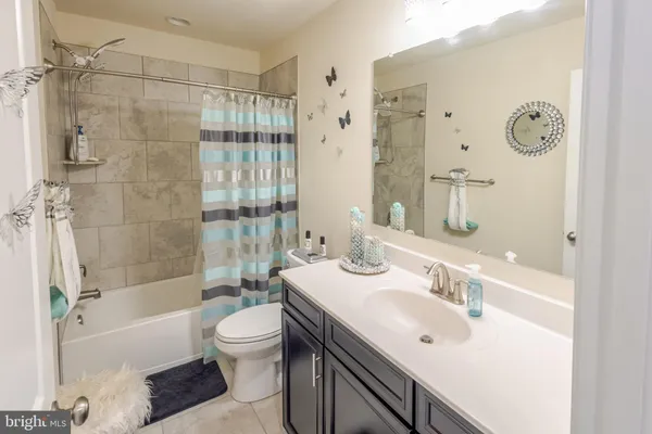 a bathroom with a bathtub shower sink vanity and toilet