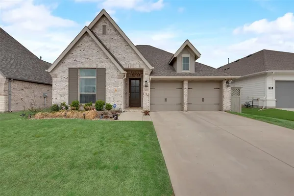 a front view of a house with a garden and plants