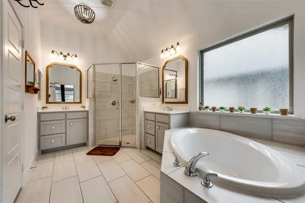 a bathroom with a tub sink and mirror