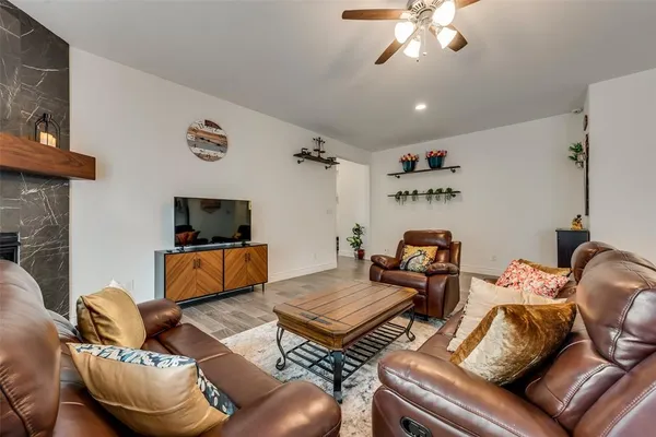 a living room with furniture a flat screen tv and a fireplace