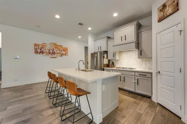 a kitchen with stainless steel appliances granite countertop a white cabinets and wooden floor