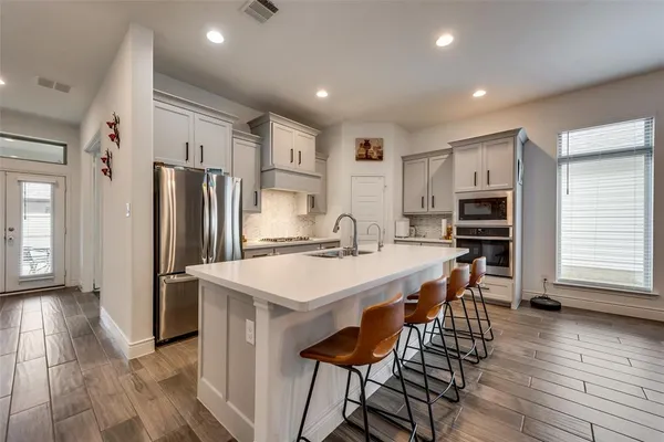 a kitchen with stainless steel appliances a refrigerator and a stove top oven