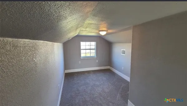 en empty room with windows and chandelier