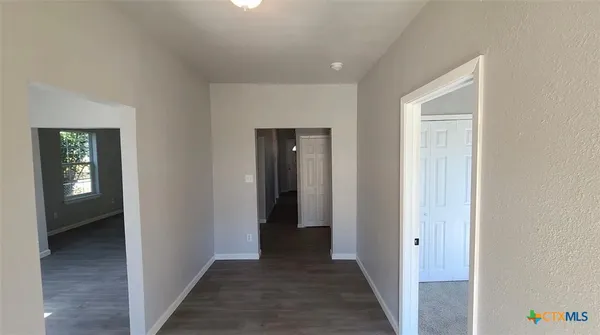 a view of a hallway with wooden floor and closet