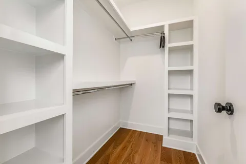 a view of walk in closet with empty racks