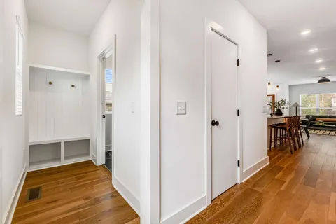a view of a hallway with wooden floor and dining room