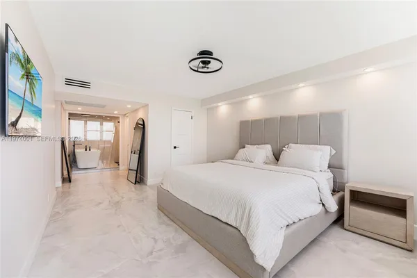 a spacious bedroom with a bed and a chandelier