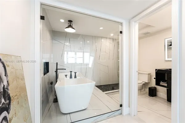 a bathroom with a bathtub shower and sink