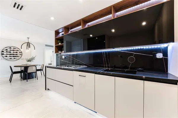 a kitchen with granite countertop a stove a sink and a microwave