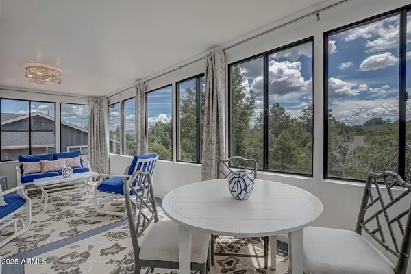 a dining room with furniture and large windows