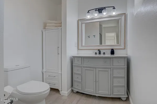 a bathroom with a toilet sink vanity and mirror