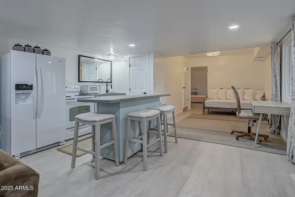 a kitchen with stainless steel appliances kitchen island granite countertop a table chairs sink and cabinets