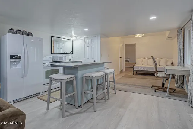 a kitchen with stainless steel appliances kitchen island granite countertop a table chairs sink and cabinets