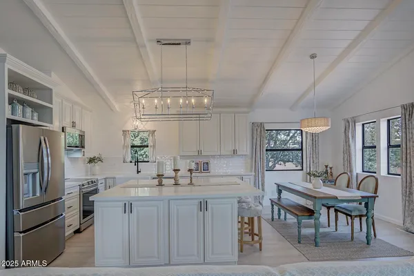 a kitchen with sink refrigerator and dining table