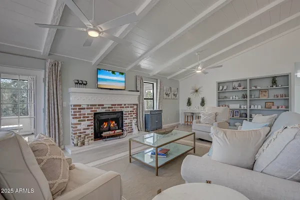 a living room with furniture a fireplace and a flat screen tv