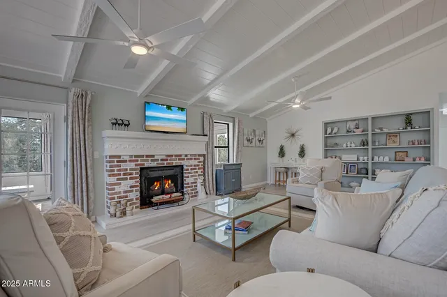 a living room with furniture a fireplace and a flat screen tv