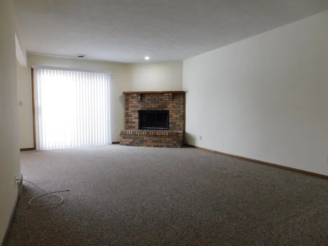 a view of empty room with a fireplace