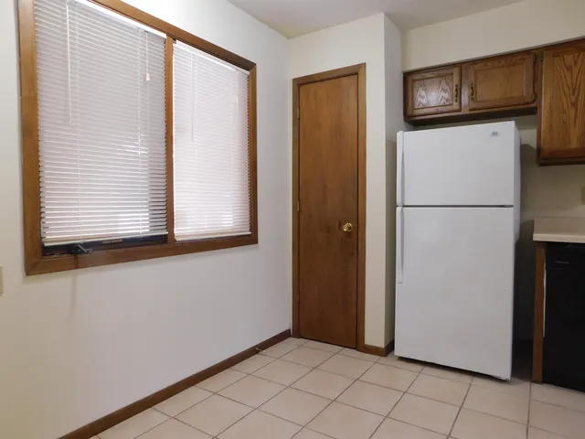 a view of a refrigerator in kitchen and a window