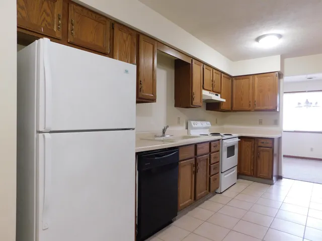 a kitchen with stainless steel appliances granite countertop a refrigerator sink and stove