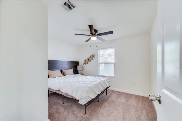 a bedroom with a bed and a ceiling fan