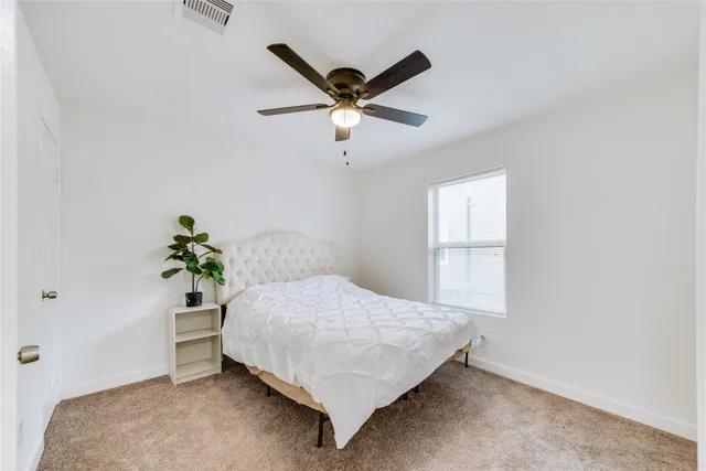 a bedroom with a bed and a ceiling fan