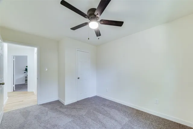 wooden floor in an empty room and a chandelier fan