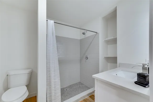 a bathroom with a sink a toilet and shower