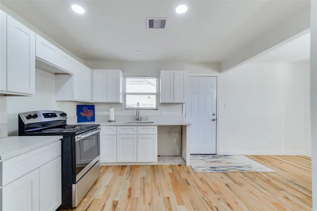 a kitchen with a sink a stove and cabinets