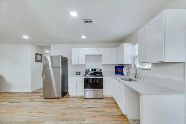 a kitchen with refrigerator a stove and cabinets