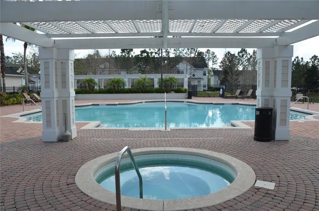 a swimming pool with outdoor seating and plants