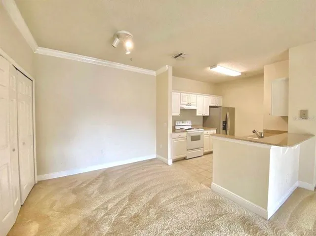 a view of kitchen with kitchen island a counter top space a sink stainless steel appliances and cabinets