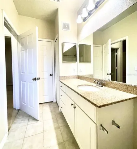 a bathroom with a granite countertop sink and a mirror
