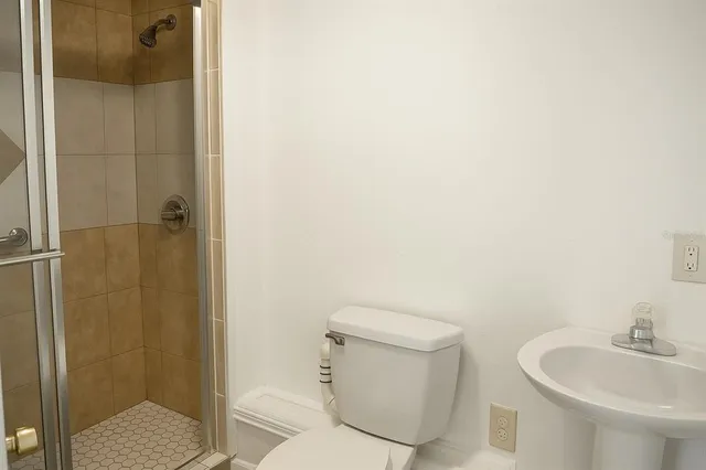 a bathroom with a toilet a sink and shower