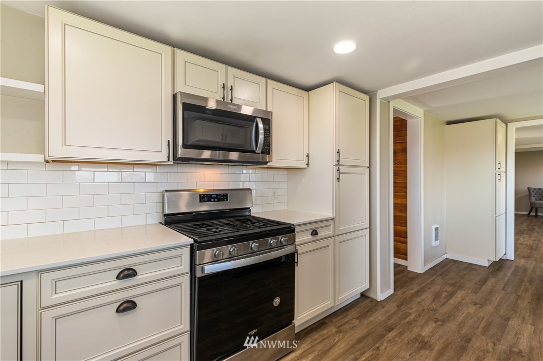 1077 Hampton Road Lynden, WA 98264 - Photo 6 of 25 a kitchen with stainless steel appliances white cabinets and a stove top oven