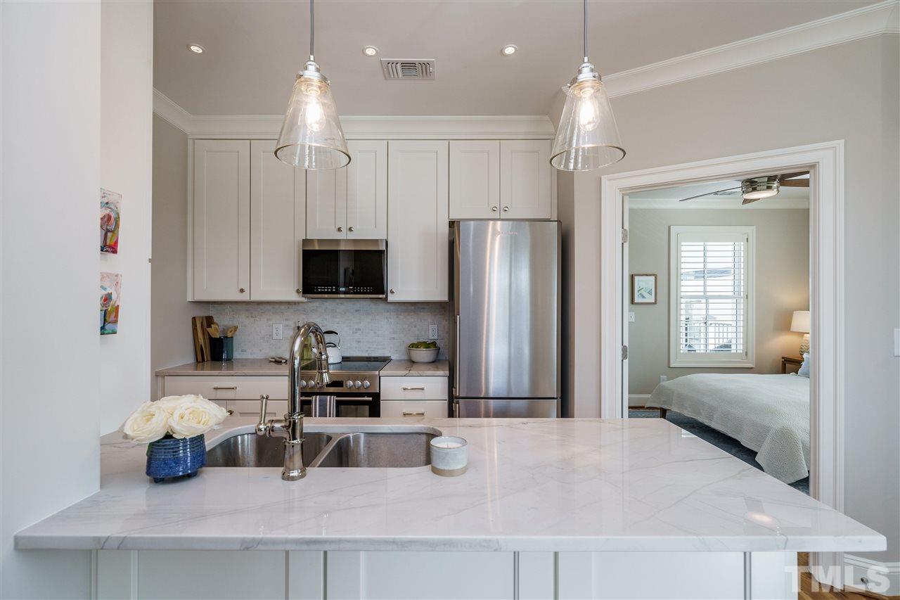 604 Daniels Street, Unit B Raleigh, NC 27605 - Photo 6 of 20 a kitchen with refrigerator a sink and cabinets