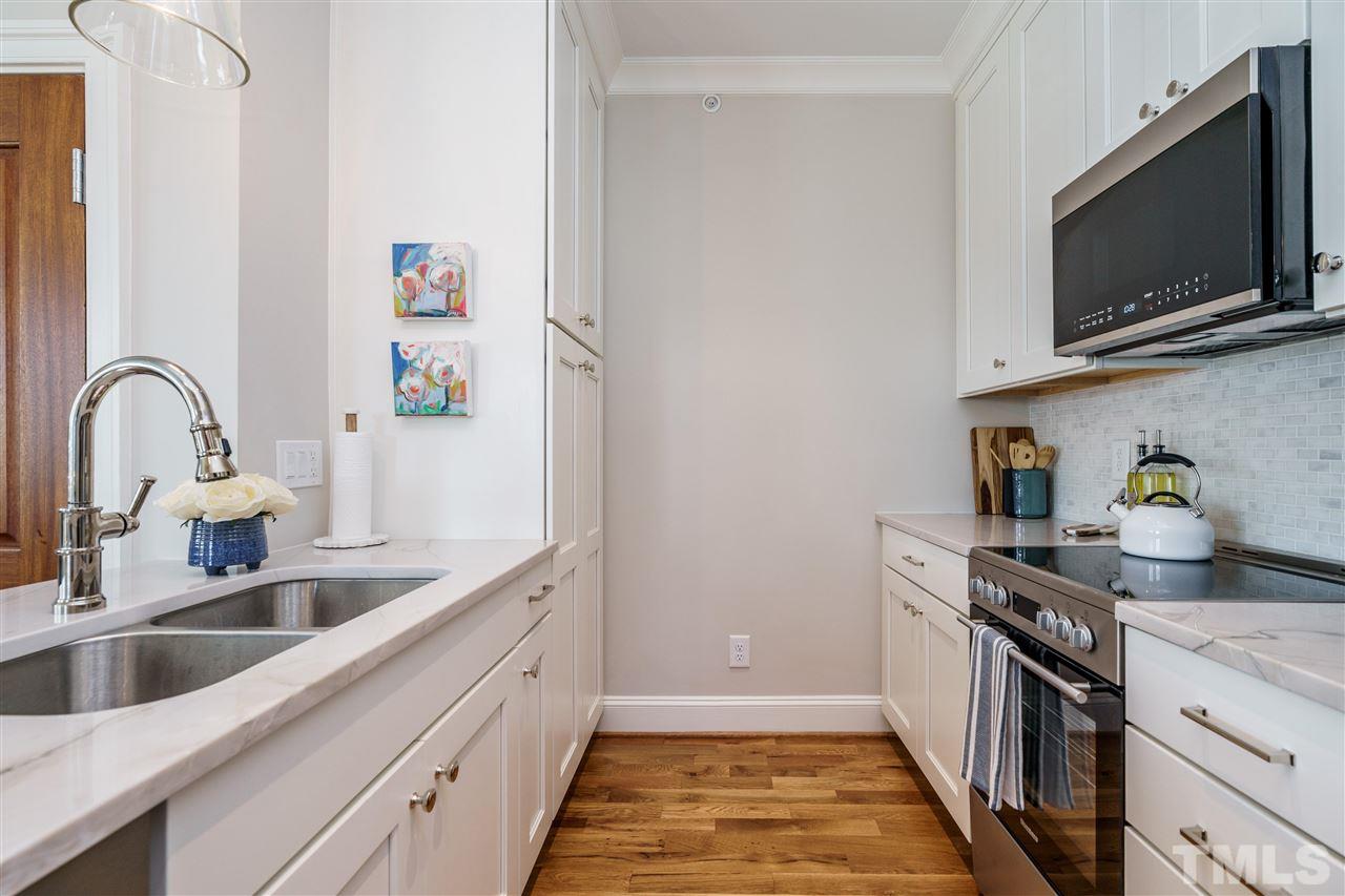 604 Daniels Street, Unit B Raleigh, NC 27605 - Photo 7 of 20 a kitchen with stainless steel appliances granite countertop a sink a stove and a microwave