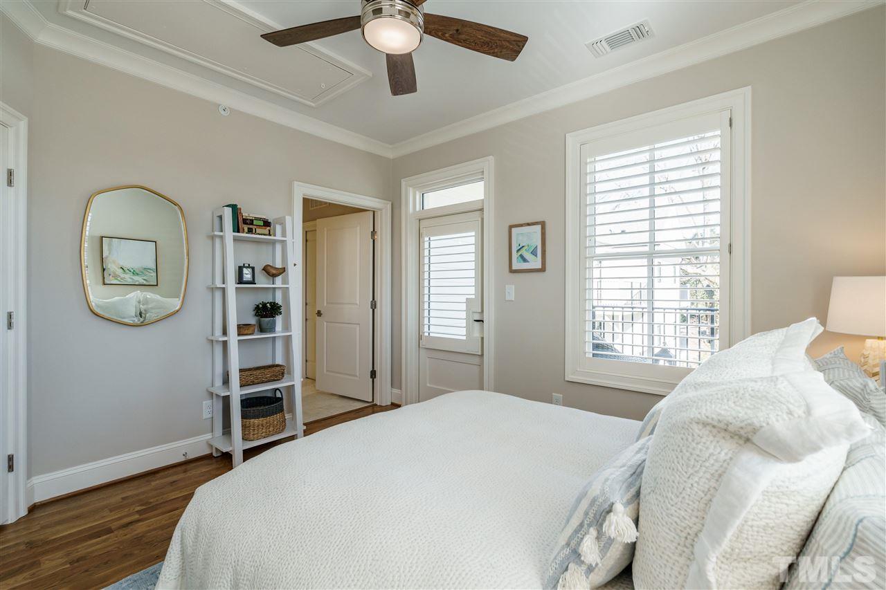 604 Daniels Street, Unit B Raleigh, NC 27605 - Photo 10 of 20 a bedroom with a bed and a chandelier