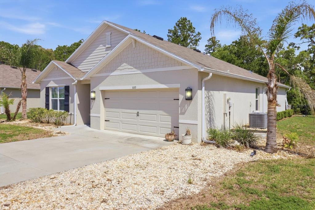 660 Hickory Course Loop Ocala, FL 34472 - Photo 2 of 45 a front view of a house with a yard and garage