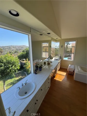 a bathroom with a granite countertop sink and a large mirror