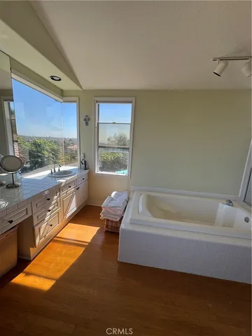 a bathroom with a tub sink and mirror