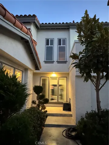 a view of a house with a large window and potted plants
