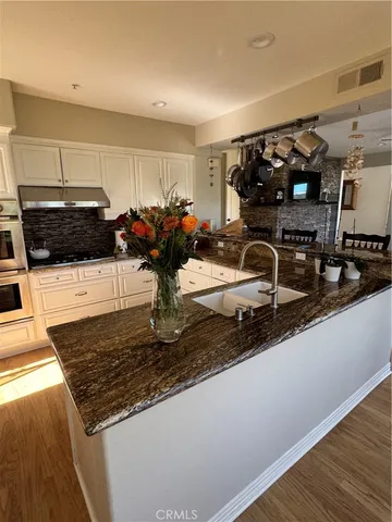 a kitchen with stainless steel appliances granite countertop a sink stove and cabinets