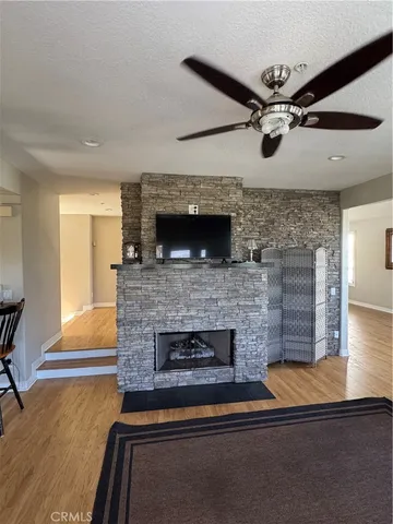 a living room with a fireplace and a ceiling fan