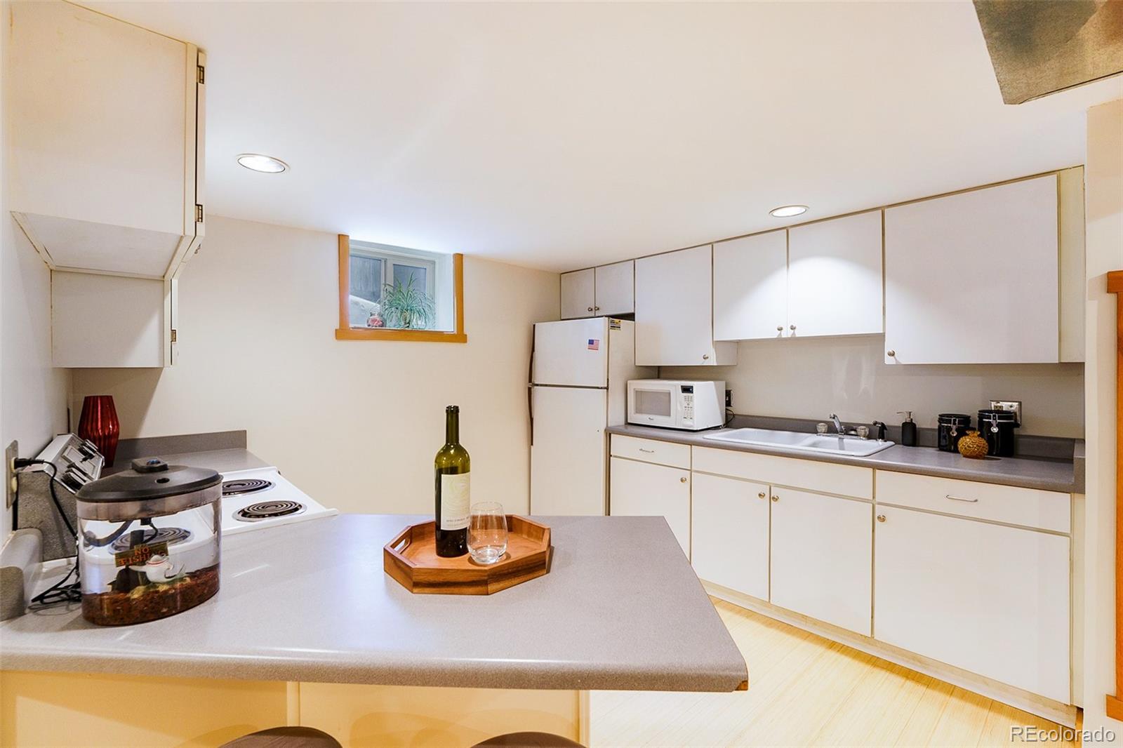 3548 Clay Street Denver, CO 80211 - Photo 23 of 30 a kitchen with white cabinets and stove