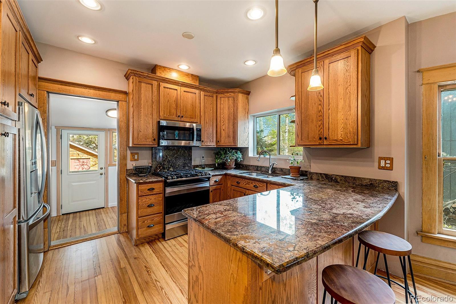 3548 Clay Street Denver, CO 80211 - Photo 8 of 30 a kitchen with granite countertop kitchen island stainless steel appliances a sink stove and refrigerator