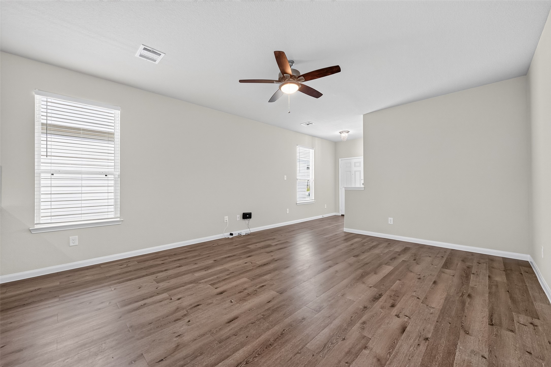 2526 Sturgeon Way Conroe, TX 77384 - Photo 12 of 49 This room is spacious and bright, featuring light wood flooring and neutral-colored walls. It has large windows for natural light and a ceiling fan for circulation, offering a comfortable and inviting living space.