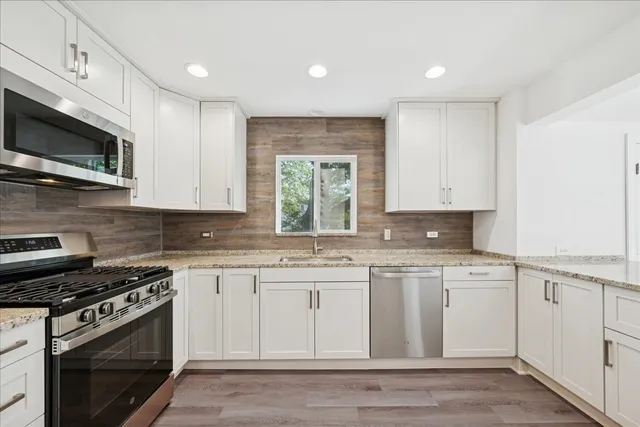 a kitchen with stainless steel appliances granite countertop a stove and a microwave